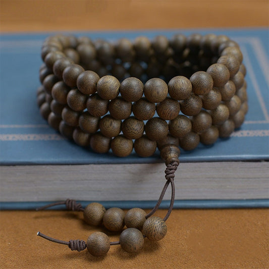 108 mala beads agarwood bracelet display on a book