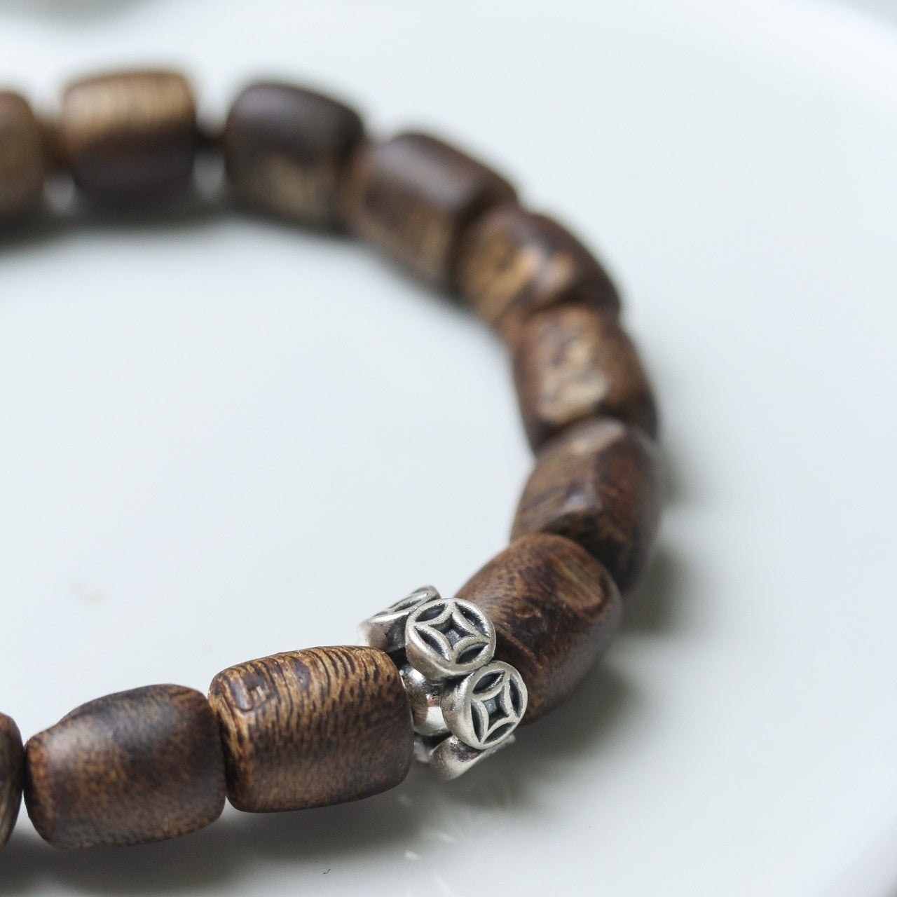 Detailed close-up of the agarwood beads and silver accents on the bracelet