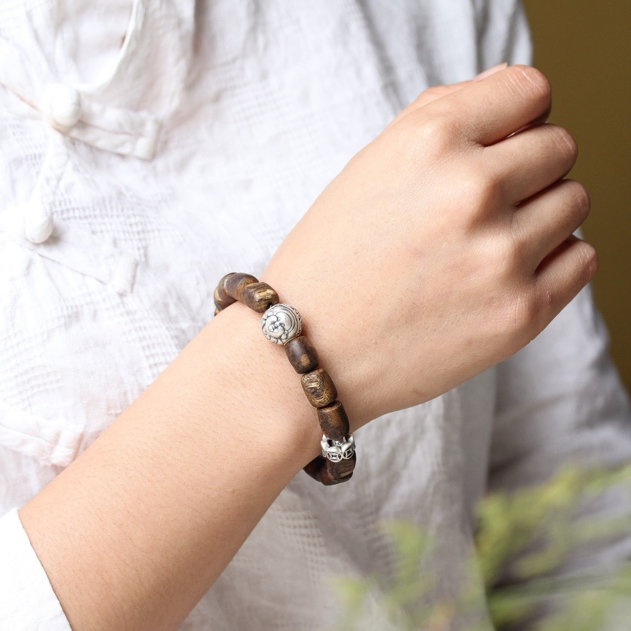 The Agarwood Silver Strength Calm Bracelet worn on the wrist, showcasing its elegant design