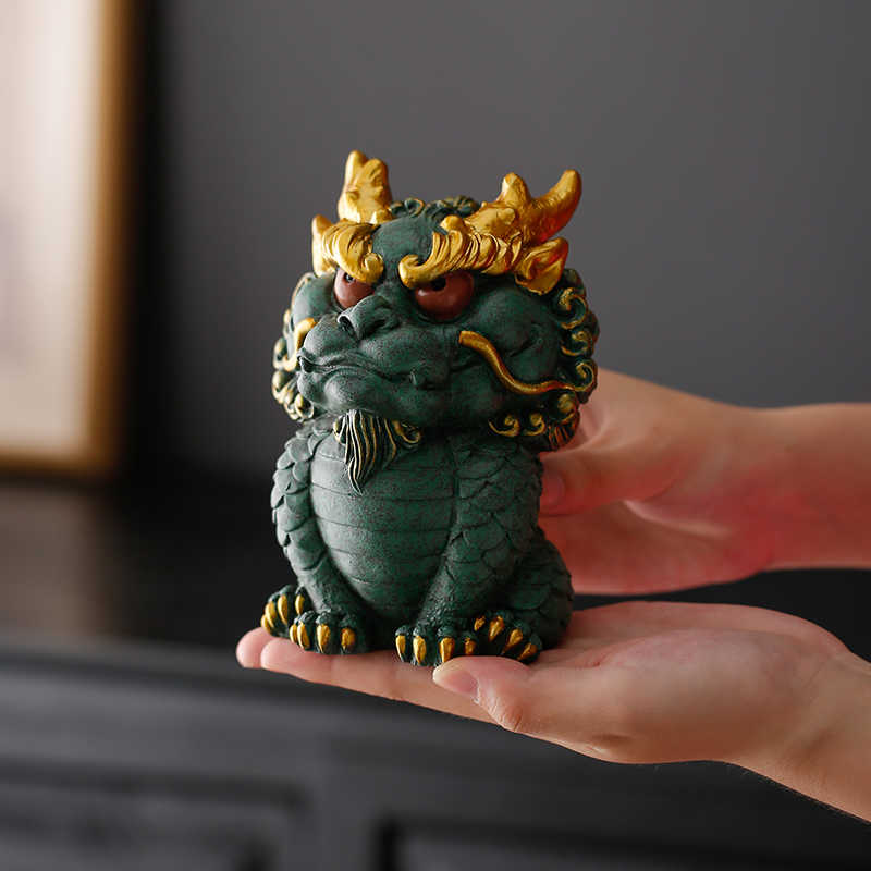 Hand-carved Qing Sha Stone Chinese dragon statue displayed on a hand.