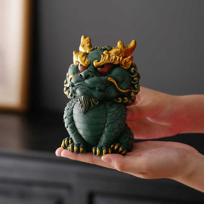 Hand-carved Qing Sha Stone Chinese dragon statue displayed on a hand.