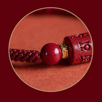 Detailed view of cinnabar accessory with engraved blessing on Tibetan Red String Bracelet