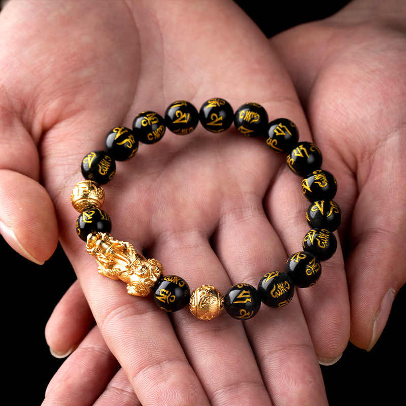 Feng Shui Pi Xiu Obsidian Bracelet held in hand, symbolizing protection and wealth