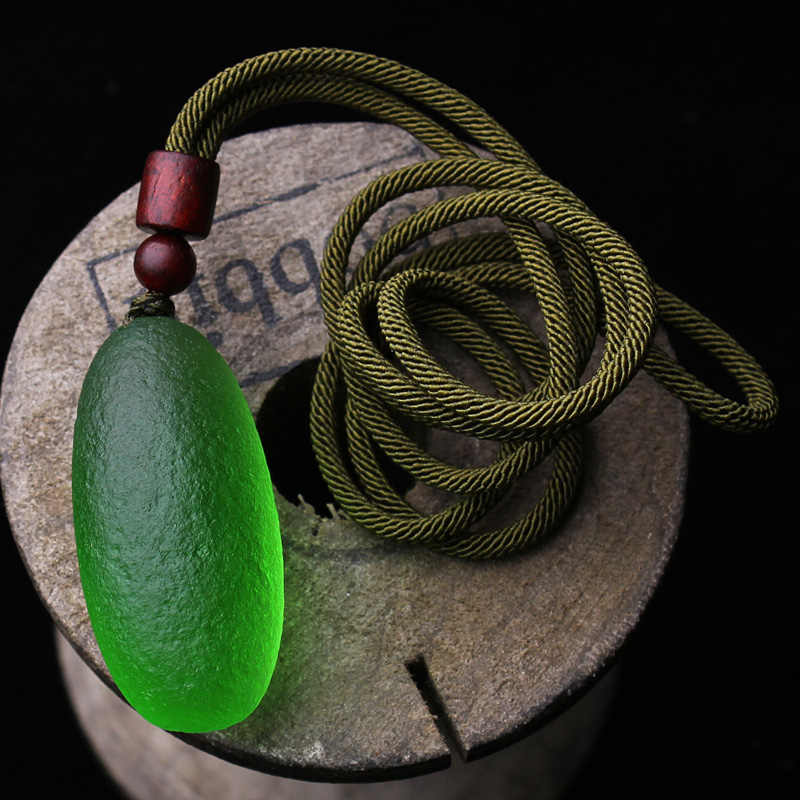 Close-up of the green meteorite pendant necklace, highlighting the natural meteorite stone and its intricate design