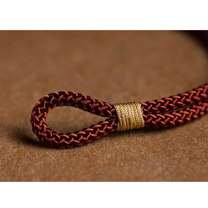 Close-up of handmade red string bracelet, showcasing its quality