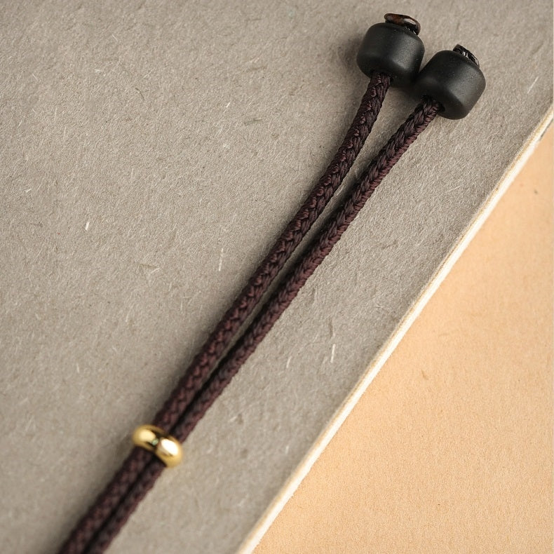 Detailed view of the necklace cord, featuring adjustable length and comfortable fit