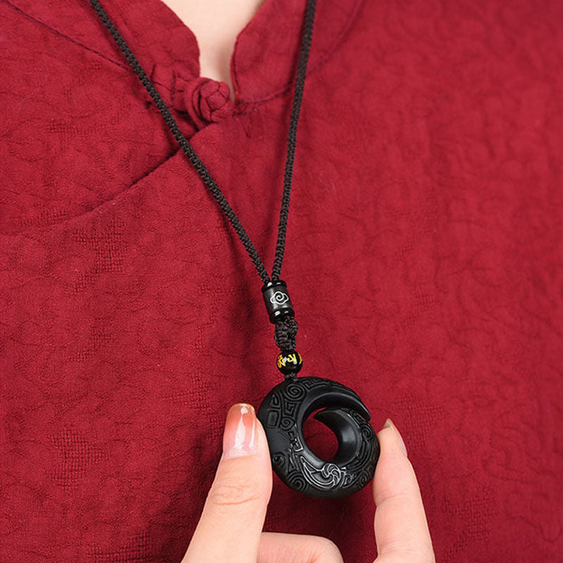 Obsidian pendant manifesting necklace worn on neck, symbolizing prosperity and positive energy