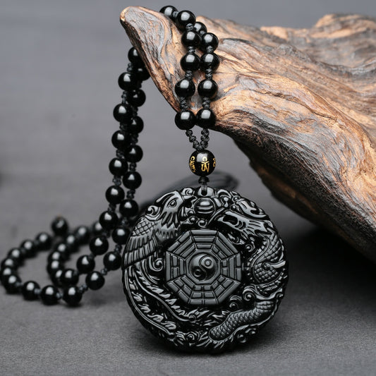 Obsidian pendant necklace with carved dragon and phoenix design, symbolizing good fortune