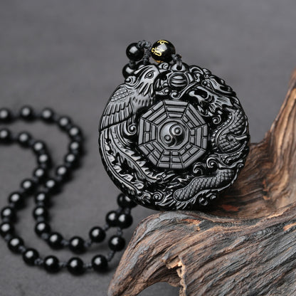 Obsidian pendant necklace with intricate dragon and phoenix design, symbolizing harmony and luck