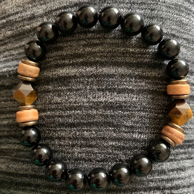 Detailed view of the black obsidian and tiger eye beads, showing their natural texture and shine