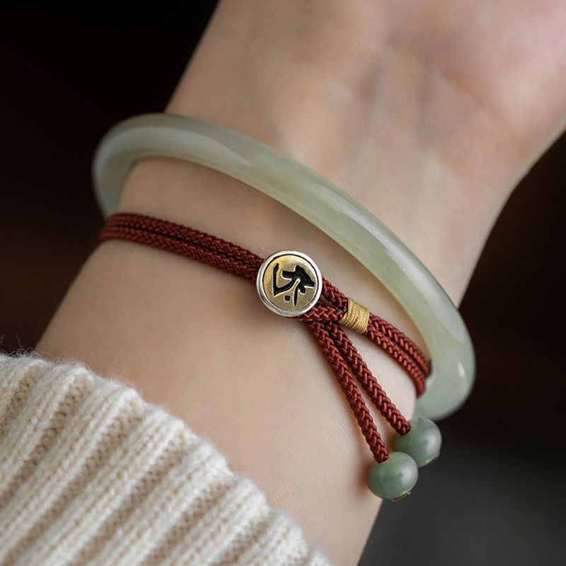 Hand wearing Handmade Red String Protection Bracelet with Zodiac Buddha Charm