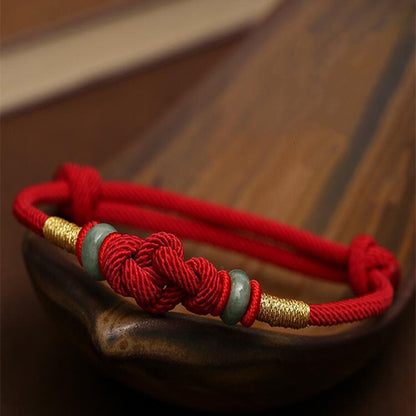 Close-up of the red string jade lover's knot bracelet with jade beads and knot detail