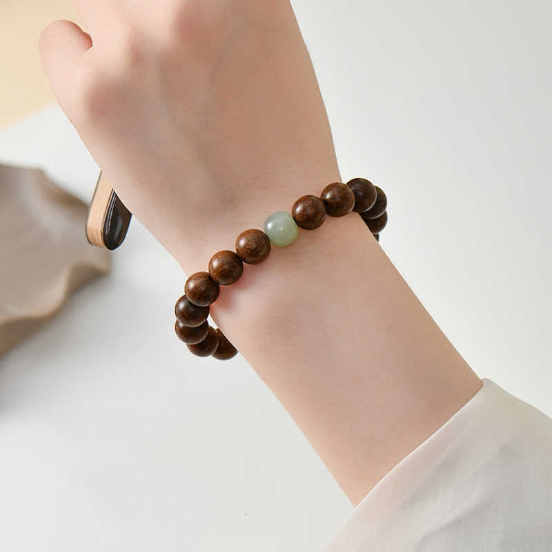 Close-up of Sandalwood & Hetian Jade Buddhist Mala Bracelet worn on wrist, Wooden Beads for Spiritual Peace