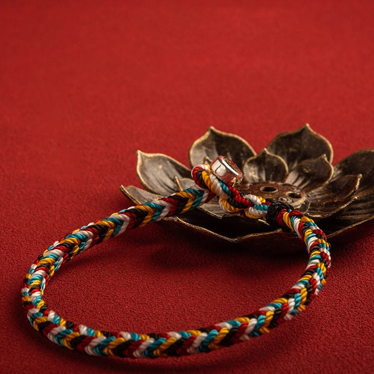 Close-up of Tibet Handmade Protection Braid Bracelet with red background, highlighting intricate details