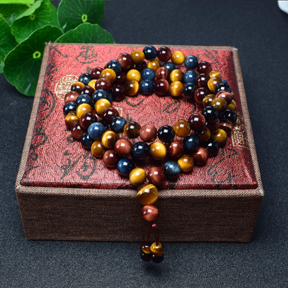 ibet Tiger's Eye Mala Bracelet displayed on green leaves, symbolizing spiritual protection