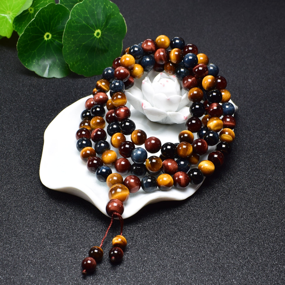 Tibetan 108 Tiger's Eye Mala on green leaves, symbolizing harmony and energy balance