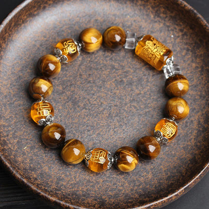 Close-up view of Tiger's Eye bracelet with Three-Faced God crystal charm