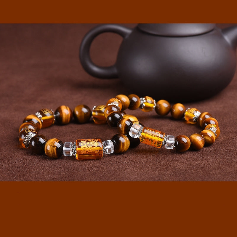 Side view of Tiger’s Eye bracelet, showcasing the Three-Faced God crystal charm