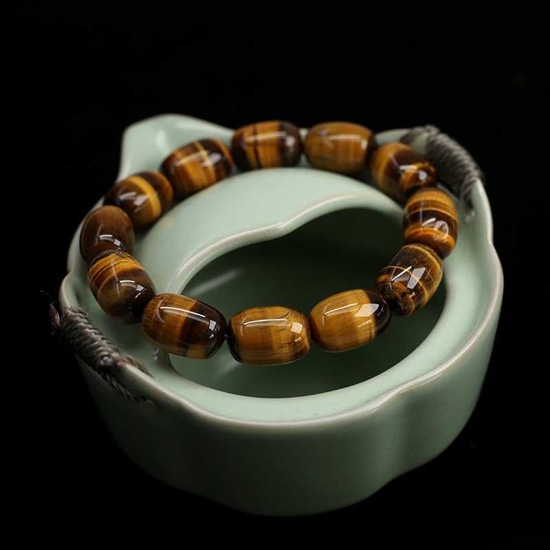 Natural Tiger's Eye Wisdom Bracelet shown on textured background, highlighting the barrel-shaped beads