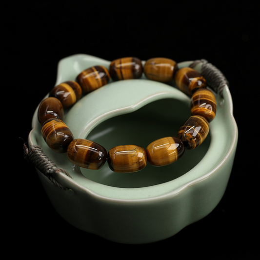 Natural Tiger's Eye Wisdom Bracelet shown on textured background, highlighting the barrel-shaped beads