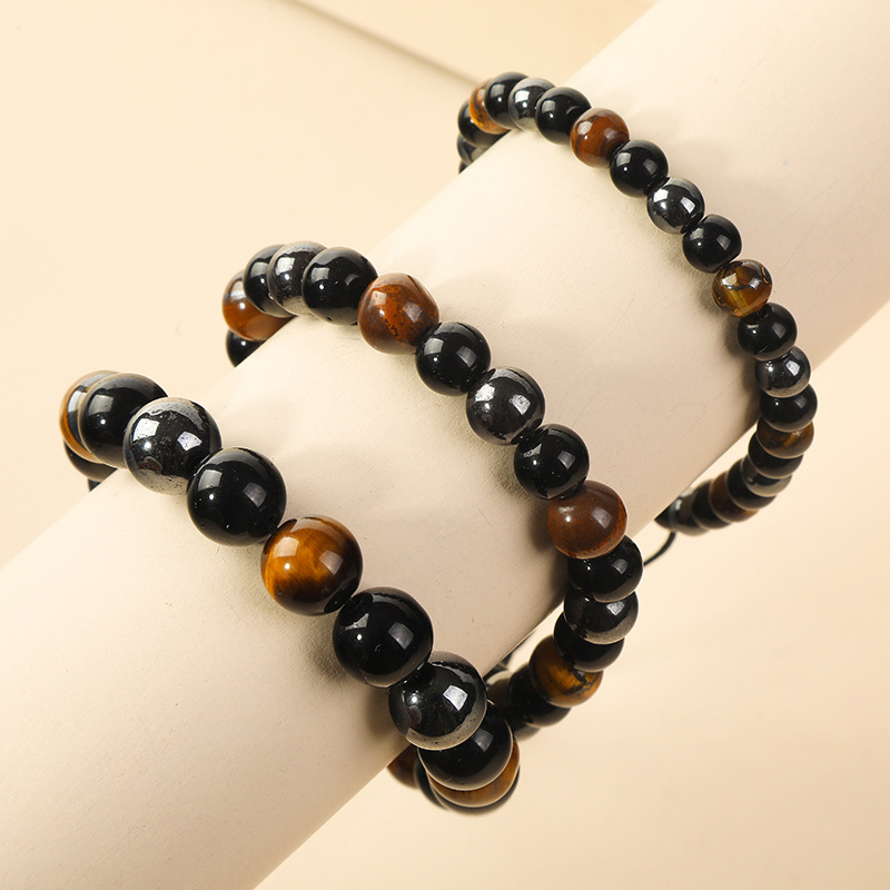 Size comparison of the Triple Protection Energy Bracelet with Tiger Eye, Obsidian, and Hematite stones