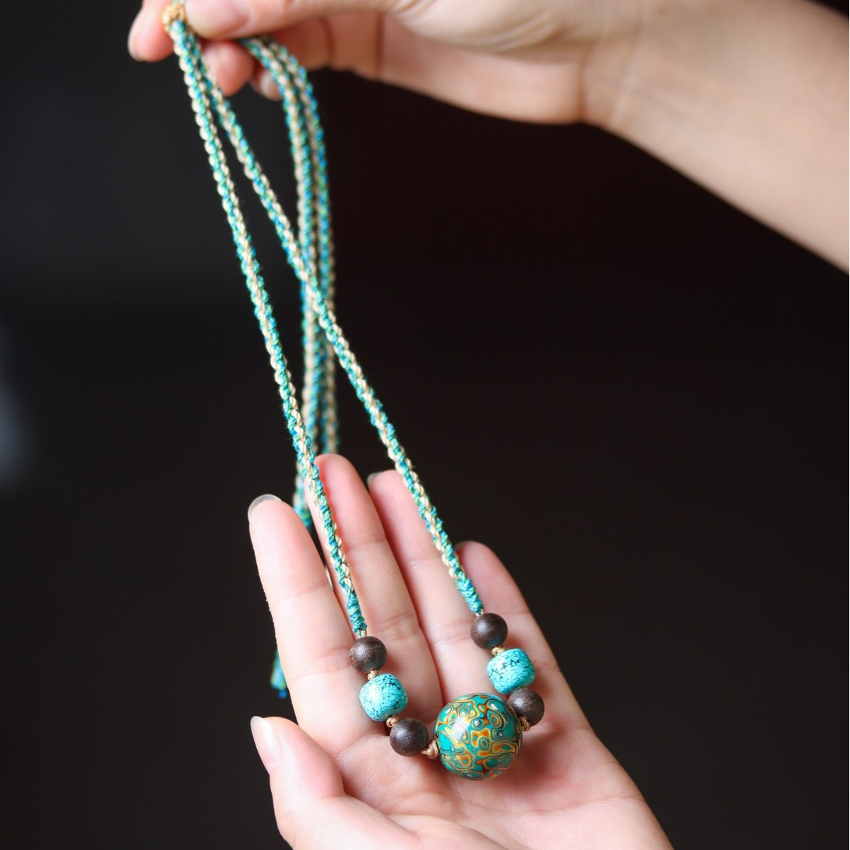 Turquoise & Lacquered Bead Serenity Necklace worn on hand to showcase its design and eleganc