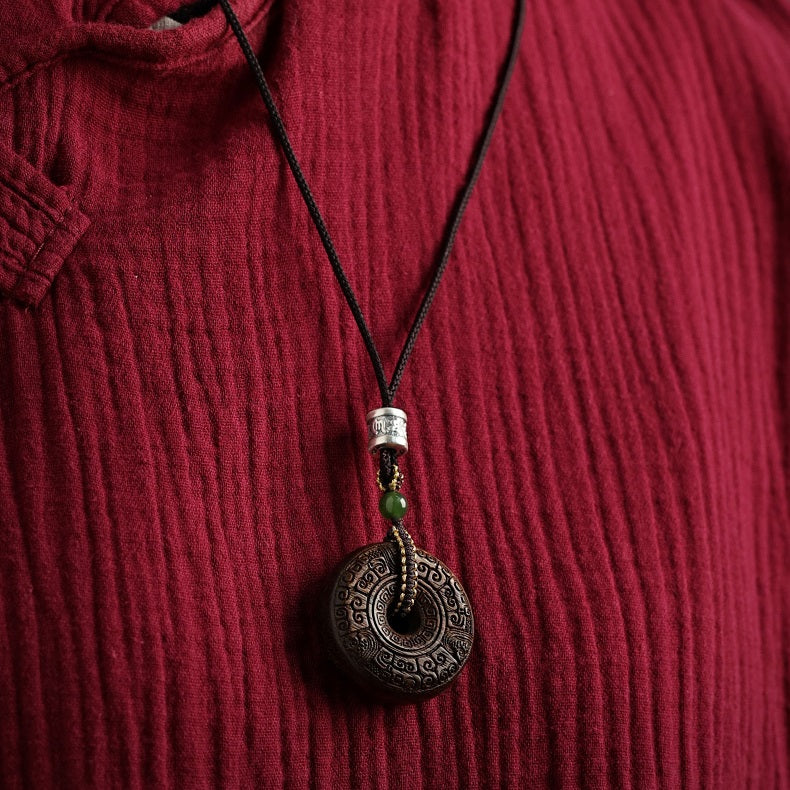 Wood pendant necklace worn, highlighting its grounding and healing properties