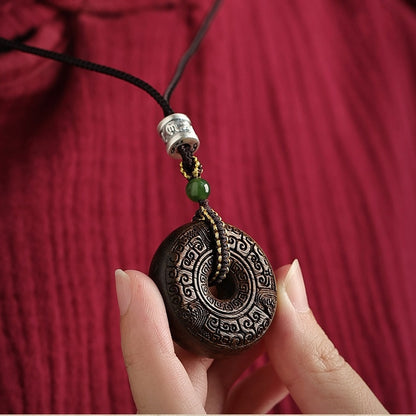 Wooden necklace with agarwood pendant worn around the neck