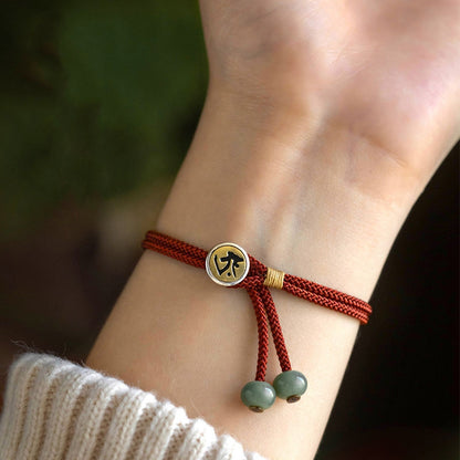 Close-up of hand wearing the Handmade Red String Protection Bracelet with Buddha charm